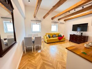 a living room with a yellow couch and a table at City buzz by Mili in Belgrade
