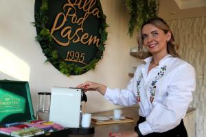 a woman standing in front of a coffee machine at Willa Pod Lasem in Tupadły