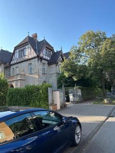 un coche azul estacionado frente a una casa en Ruhige Stadtperle mit Garten, en Wiesbaden