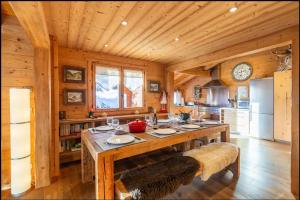 a kitchen with a large wooden table in a cabin at Chalet Coelacanthe in La Clusaz