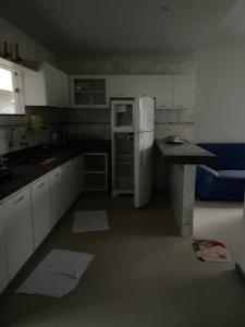 een keuken met een witte koelkast en een aanrecht bij Villa Rainer in Porto Seguro