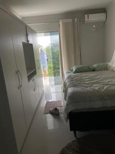 een slaapkamer met een bed en een deur naar een balkon bij Villa Rainer in Porto Seguro +6 foto's