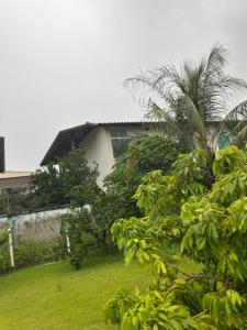 een huis met een palmboom in een tuin bij Villa Rainer in Porto Seguro