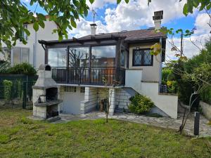 a house with a balcony and an outdoor oven at Maison Paris, Vallée Village, Disney & Astérix in Chelles