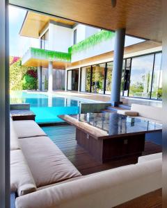 a living room with a pool and a house at House Of Sea Breeze in Uluwatu