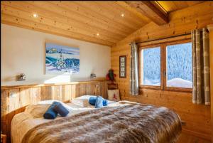 a bedroom with a large bed in a cabin at Chalet Coelacanthe in La Clusaz