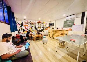a group of people sitting in a room with laptops at Urban Loft Hostel in Rishīkesh