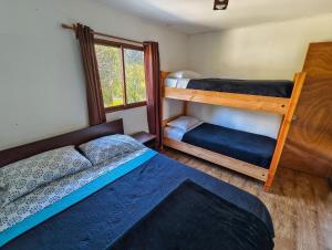 una camera con 2 letti a castello e una finestra di Habitación n°4 | Hostal La Casona Pucón a Pucón