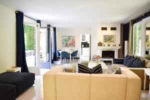 a living room with two couches and a dining room at La Verdoyante -Tennis Piscine-Proche Pont L'Evêque in Surville