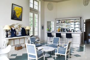 a room with a bar with chairs and a table at La Verdoyante -Tennis Piscine-Proche Pont L'Evêque in Surville