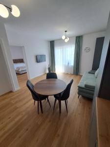 Una sala de estar con una mesa y sillas y un sofá. en Studio Elisabeth, en Şelimbăr