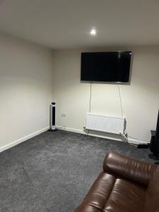 a living room with a couch and a flat screen tv at Guest Village in Hull