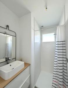 a white bathroom with a sink and a shower at La baie, maison neuve proche des plagesMaison neuve, proche des plages, Mousterlin in Fouesnant +12 photos