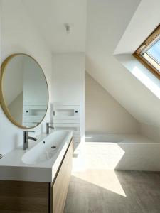 a white bathroom with a sink and a mirror at La baie, maison neuve proche des plagesMaison neuve, proche des plages, Mousterlin in Fouesnant