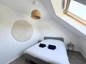 a bedroom with a white bed with two pillows on it at La baie, maison neuve proche des plagesMaison neuve, proche des plages, Mousterlin in Fouesnant