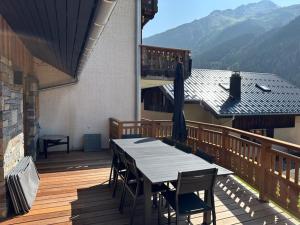 a wooden deck with a table and chairs on a house at Nouveau ! Chalet pied des pistes in Champagny-en-Vanoise