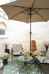a patio with two chairs and a table with an umbrella at 5&6 North Place in Gloucestershire