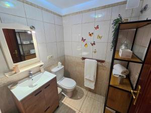 Un baño con inodoro, lavabo y espejo. en Hada Coast Apartment Playa San Juan, en Playa de San Juan 32 fotos más