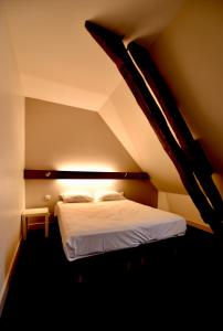 a bedroom with a white bed in a room at Le Relais du Château in Saint-Fargeau
