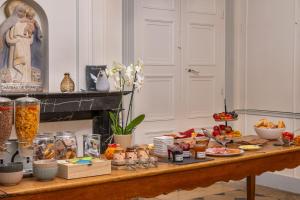 a table filled with food and a statue of a woman at Château de Briançon, The Originals Relais in Bauné