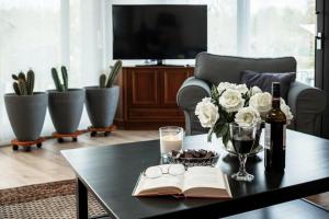 a table with a book and a bottle of wine and flowers at Ferienhaus Spessartfeeling in Hasselroth