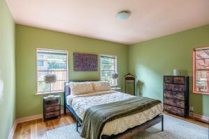a bedroom with green walls and a bed and windows at Cozy 2BR Home Near UNR with Large Deck & Parking in Reno
