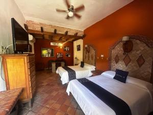 a hotel room with two beds and a flat screen tv at Hotel Olimpia Centro Histórico in Monclova
