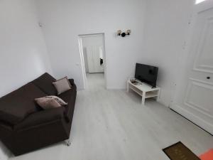 Una sala de estar con un sofá y un televisor. en Casa Azul - La Laguna, en La Laguna