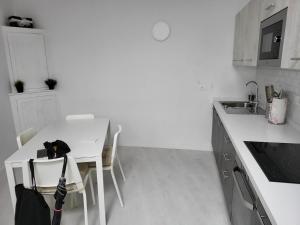 Una cocina blanca con una mesa y sillas blancas. en Casa Azul - La Laguna, en La Laguna 6 fotos más