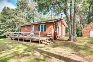 a log cabin with a porch and a tree at Cabin in Boulder Junction with Fire Pit and Deck! in Boulder Junction