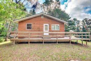 a log cabin with a large bench in front of it at Cabin in Boulder Junction with Fire Pit and Deck! in Boulder Junction