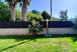 a fence with a bush next to a yard at Göcek Villa Hayal in İnlice