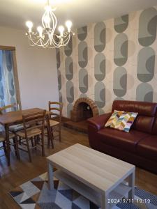 a living room with a couch and a table at Au petit nid d'Apollon in Autun