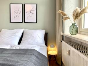 a bedroom with a bed with two pictures on the wall at Cozy one bedroom apartment in Augsburg in Augsburg +4 photos