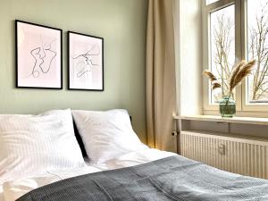 a bedroom with three pictures on the wall and a bed at Cozy one bedroom apartment in Augsburg in Augsburg