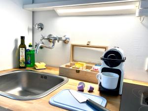 a kitchen counter with a mixer and a sink at Cozy one bedroom apartment in Augsburg in Augsburg