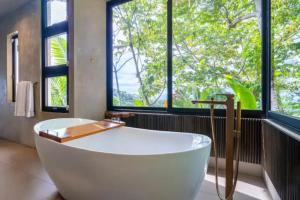 a large bath tub in a bathroom with windows at Villas Luxury Suites Pool QUEPOS COSTA RICA in Manuel Antonio +66 photos