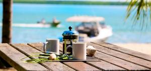 a coffee cup sitting on top of a wooden bench at Crab Claw Island in Bynoe Harbour