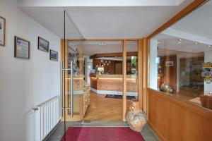 a hallway with a glass door leading to a bedroom at Rothenfels Panorama Hotel in Immenstadt im Allgäu +107 photos