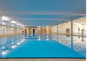 Una gran piscina con agua azul en un edificio. en FRESHWATER BEACH HOLIDAY HOME, en Burton Bradstock 30 fotos más
