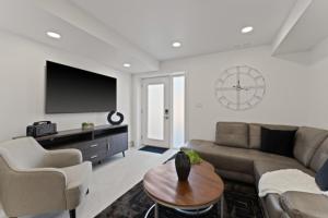 a living room with a couch and a clock on the wall at Luxury 171-7 Condos with Magnificent Lakeviews in Leamington