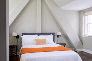 une chambre avec un grand lit avec une couverture orange dans l'établissement Downtown Luxury 1BR Loft, à Milwaukee