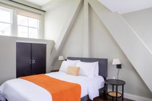 une chambre avec un grand lit avec une couverture orange dans l'établissement Downtown Luxury 1BR Loft, à Milwaukee