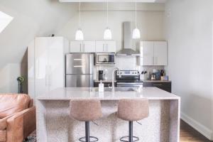 une cuisine avec un comptoir et deux tabourets de bar dans l'établissement Downtown Luxury 1BR Loft, à Milwaukee 6 autres photos