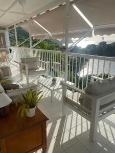 a porch with white furniture on a white deck at La Sucrière in Terre-de-Haut +6 photos