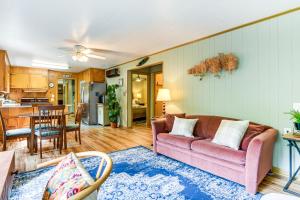 a living room with a pink couch and a kitchen at 6 Mi to Waterrock Knob Serenity Cottage in Maggie Valley
