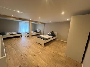 a room with two beds in a room with wooden floors at Serena Monteur Apartment in Rodenbach