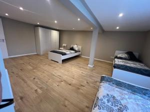 a large room with two beds and wooden floors at Serena Monteur Apartment in Rodenbach +2 photos