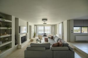 a living room with a couch and a tv at Reina del Cielo Luxury Villa in Pýrgos