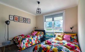 a bedroom with two beds and a window at Colourful life-house near Glasgow in Clydebank